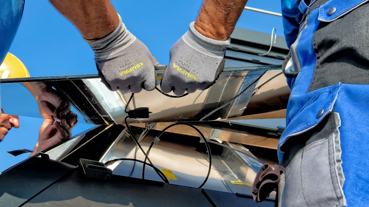 Technician installing a solar panel on site